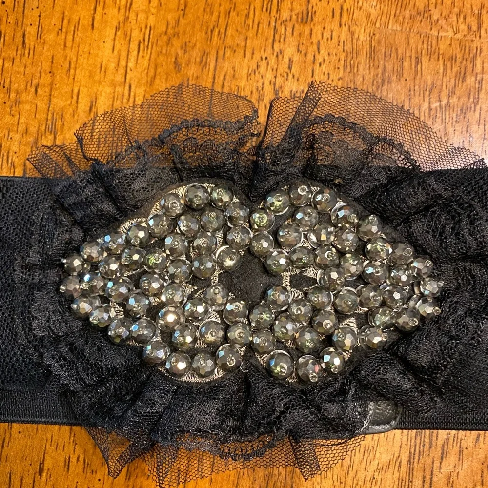black belt with lace and sequins. Stretchy Size S/M. Snap closure.